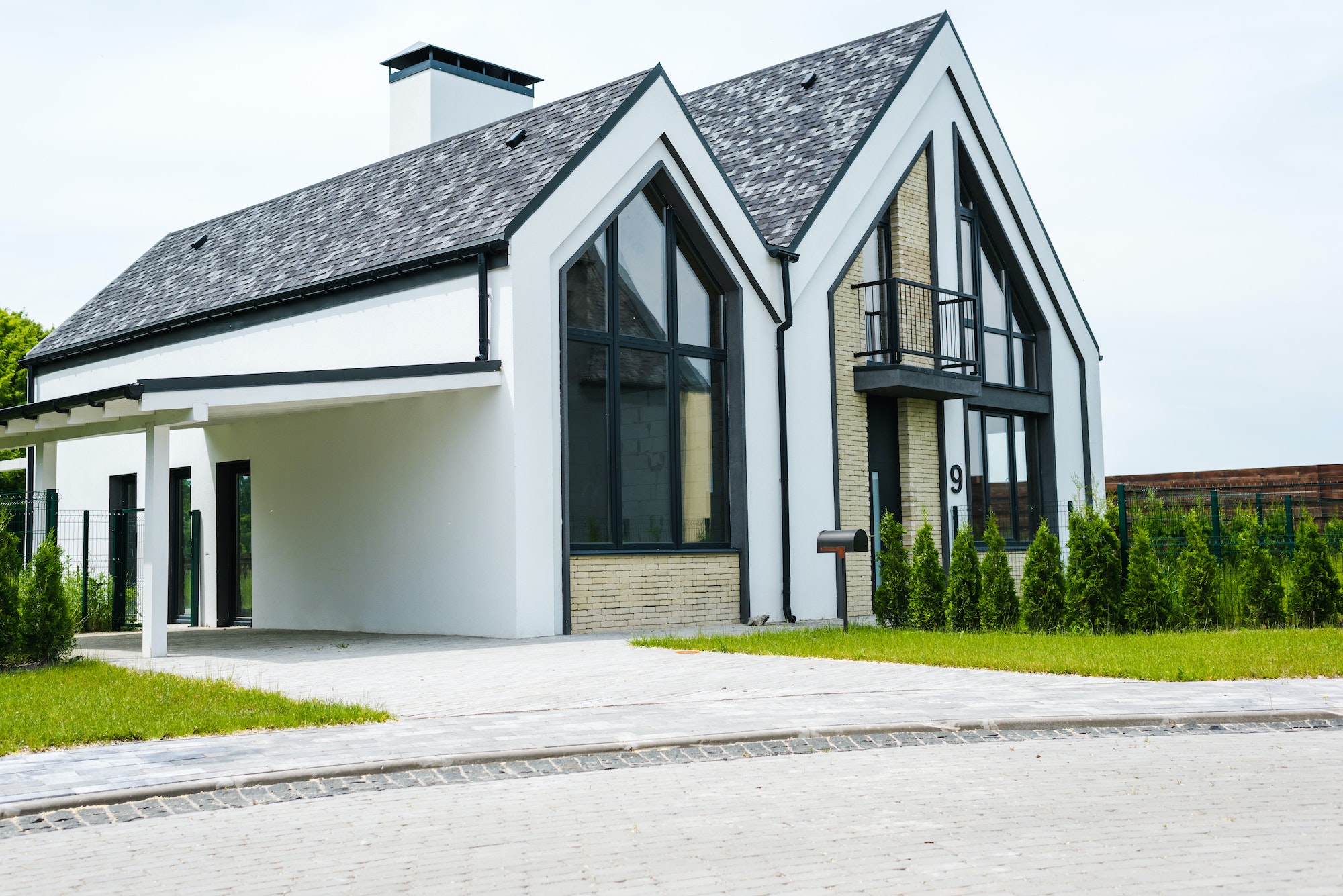 new modern and luxury home with windows and doors near green grass